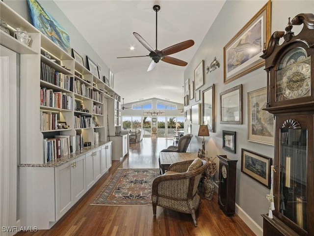 living area featuring ceiling fan, dark wood-type flooring, and lofted ceiling