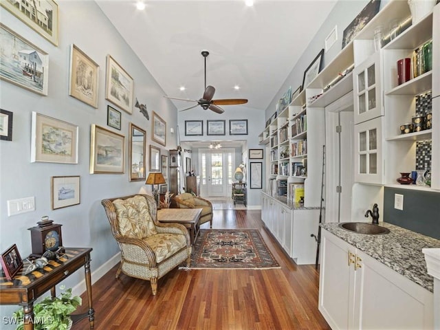 sitting room featuring dark wood-type flooring, french doors, sink, built in shelves, and ceiling fan