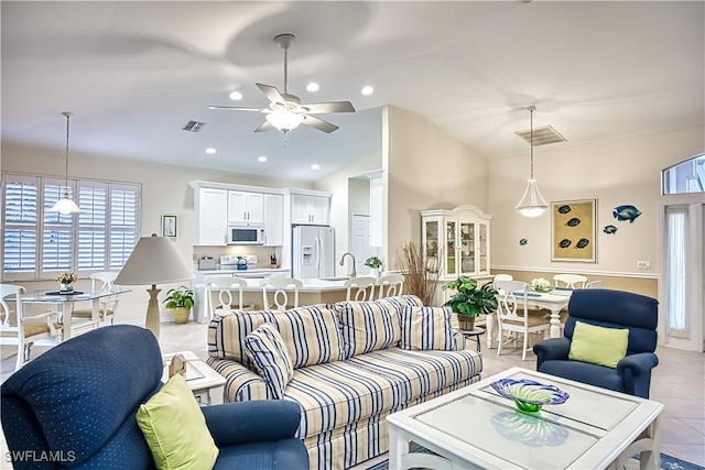 living room featuring light tile patterned floors, ceiling fan, and sink