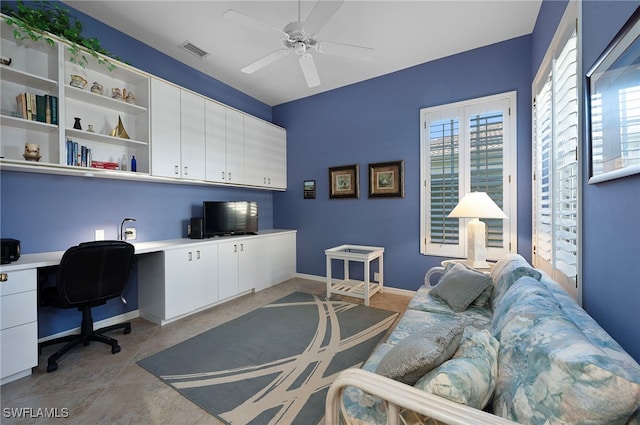 office featuring ceiling fan, light tile patterned flooring, and built in desk