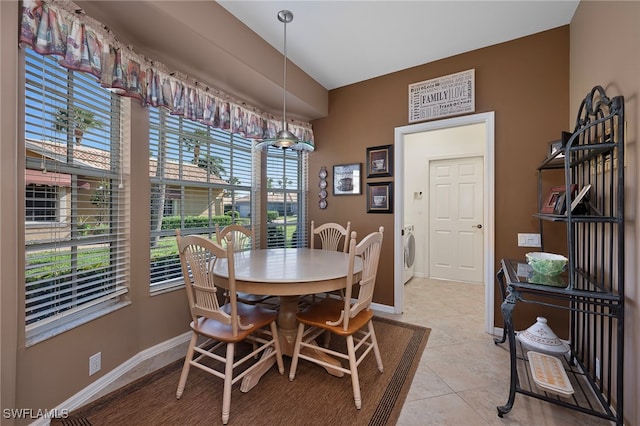 dining space with light tile patterned floors and washer / clothes dryer