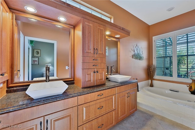 bathroom featuring tile patterned floors, vanity, and tiled tub