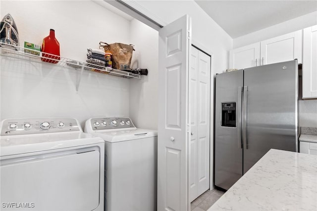 washroom featuring light tile patterned floors and washing machine and dryer