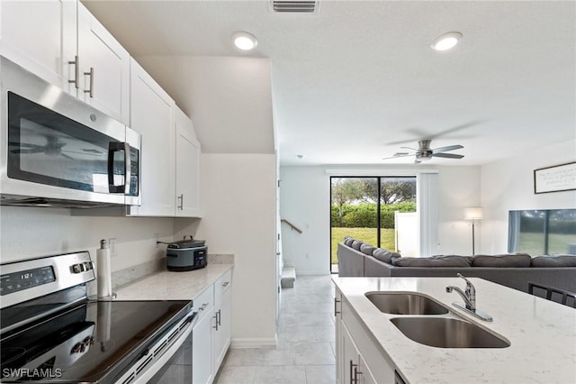 kitchen featuring white cabinetry, sink, light stone countertops, and stainless steel appliances