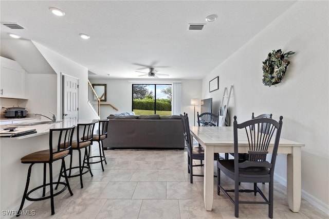 dining space featuring ceiling fan and sink