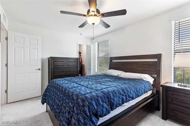 bedroom with ceiling fan, a closet, light colored carpet, and multiple windows