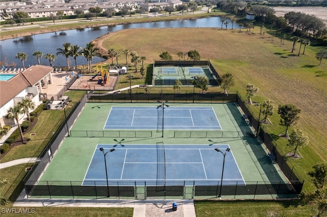 view of tennis court with a water view