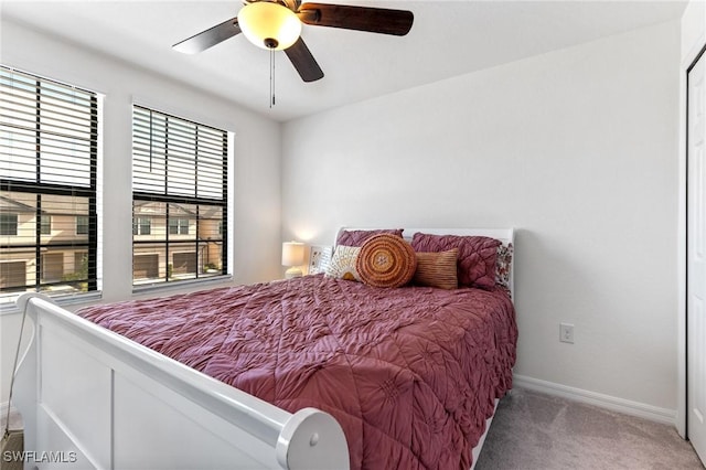 carpeted bedroom featuring multiple windows and ceiling fan