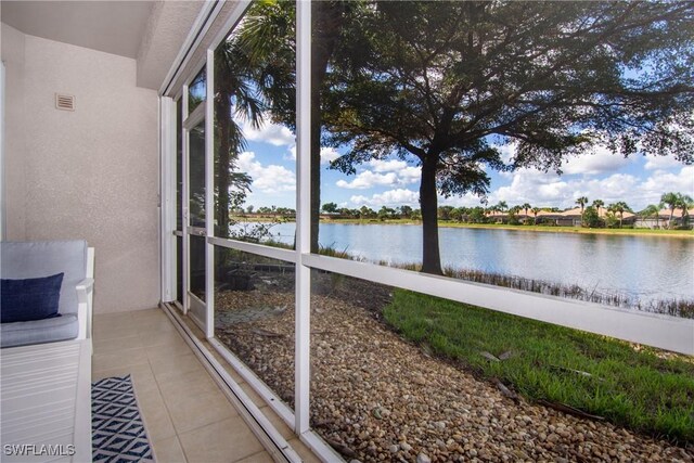 unfurnished sunroom featuring a water view