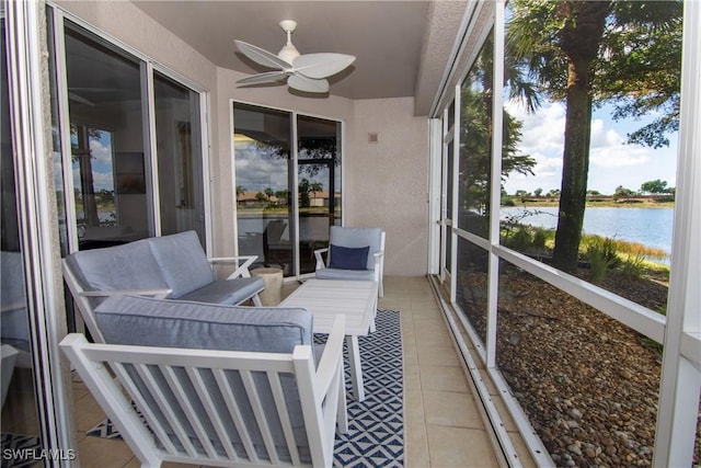 sunroom / solarium with ceiling fan and a water view