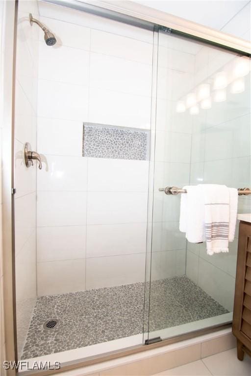 bathroom featuring tile patterned floors, vanity, and a shower with shower door