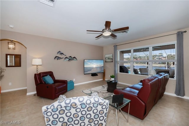 tiled living room featuring ceiling fan with notable chandelier