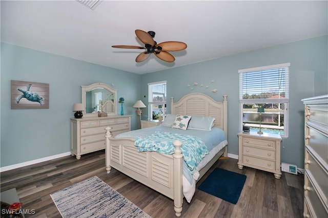 bedroom with multiple windows, ceiling fan, and dark wood-type flooring