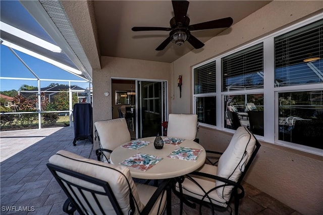 view of patio featuring glass enclosure and ceiling fan