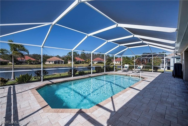 view of swimming pool featuring glass enclosure, a patio area, and a water view