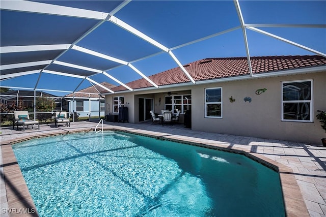 view of swimming pool with ceiling fan, a lanai, and a patio