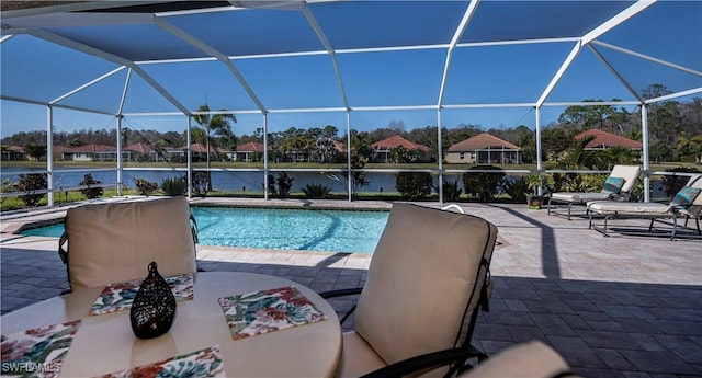 view of pool featuring a lanai, a patio, and a water view