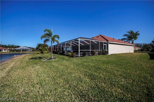 view of yard featuring a water view and glass enclosure