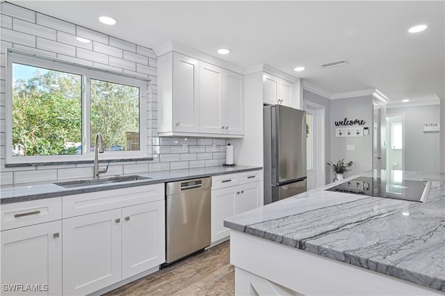 kitchen featuring white cabinetry, stainless steel appliances, tasteful backsplash, sink, and light hardwood / wood-style flooring