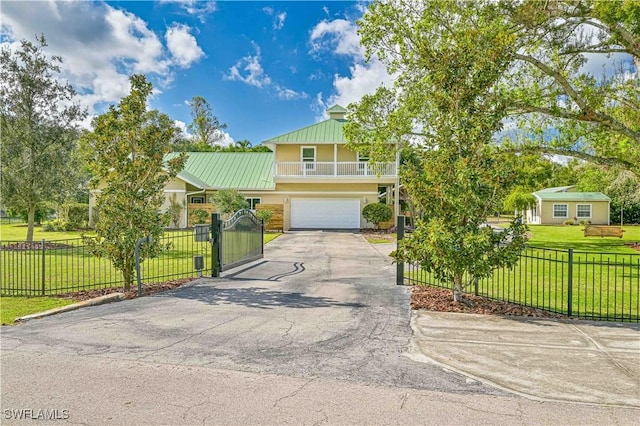 view of front of property featuring a front lawn, a balcony, and a garage