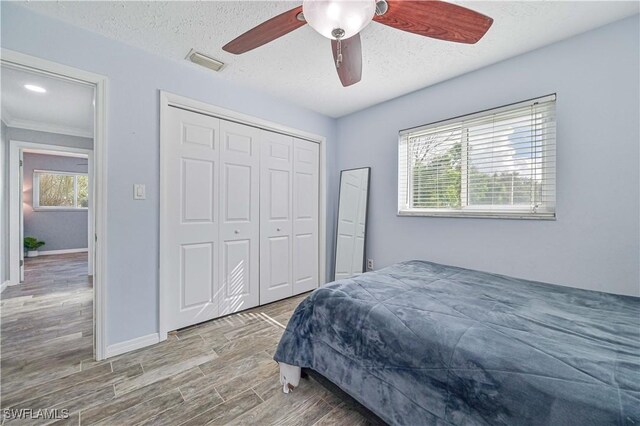 bedroom featuring a textured ceiling, ceiling fan, and a closet