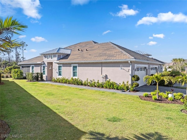 exterior space featuring a garage and a lawn