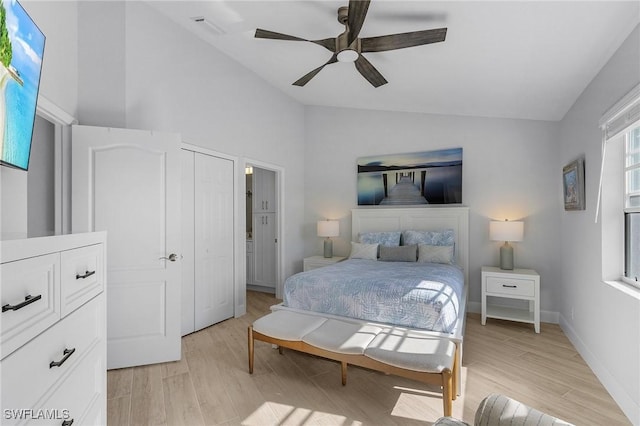 bedroom with ceiling fan, vaulted ceiling, a closet, and light hardwood / wood-style flooring