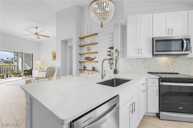 kitchen with kitchen peninsula, sink, and appliances with stainless steel finishes