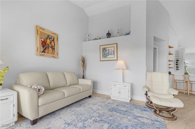 living room featuring light wood-type flooring and vaulted ceiling