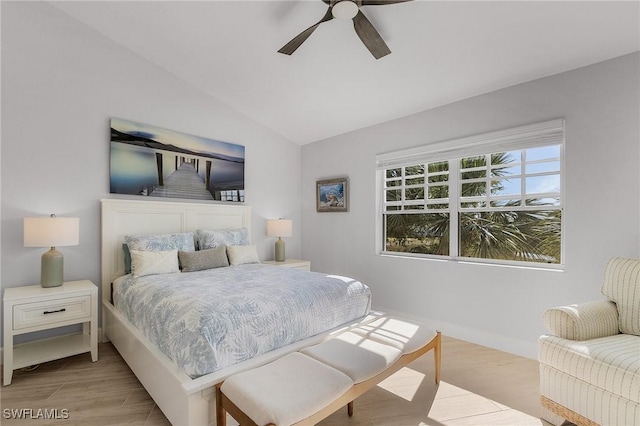 bedroom with ceiling fan, lofted ceiling, and light wood-type flooring