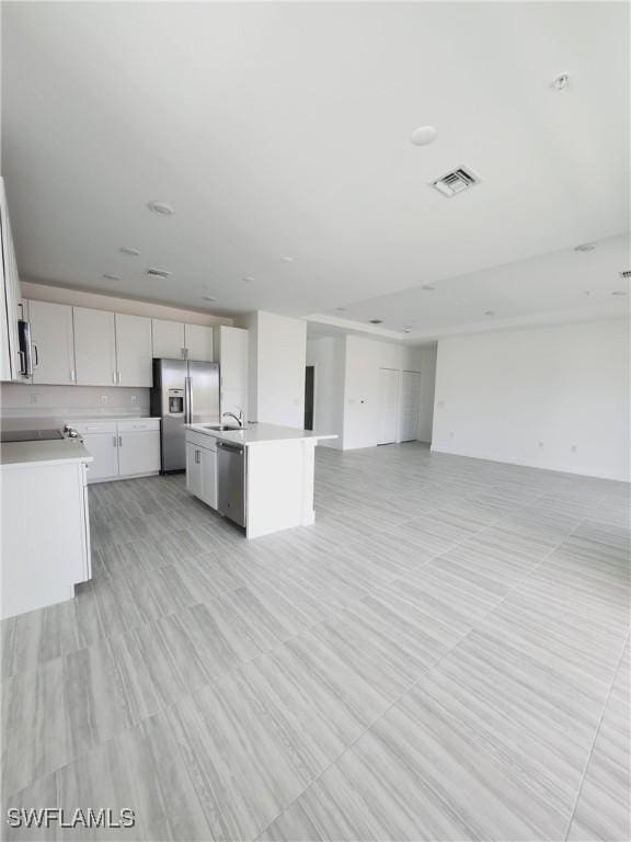 kitchen with white cabinets, sink, an island with sink, and appliances with stainless steel finishes