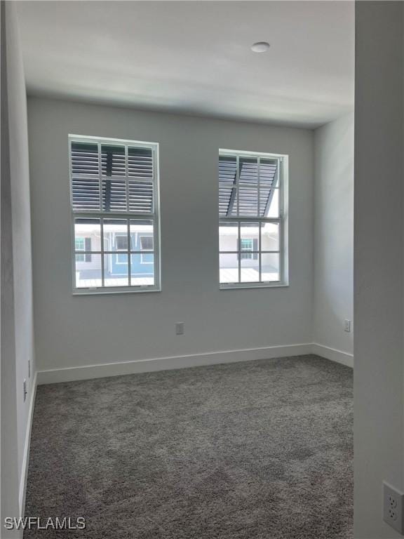 spare room featuring dark colored carpet