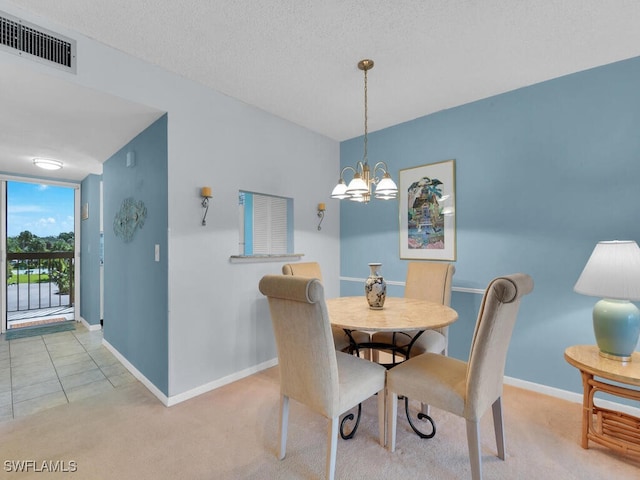 carpeted dining room featuring a textured ceiling and an inviting chandelier