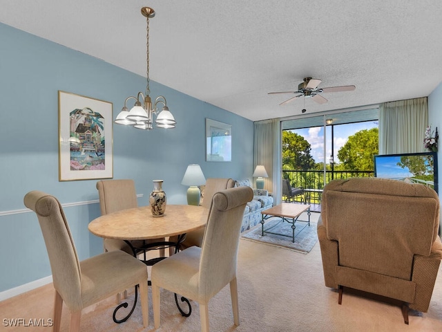 carpeted dining area with a textured ceiling and ceiling fan with notable chandelier