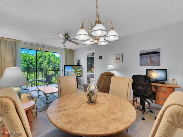 carpeted dining room featuring ceiling fan with notable chandelier, expansive windows, and a textured ceiling