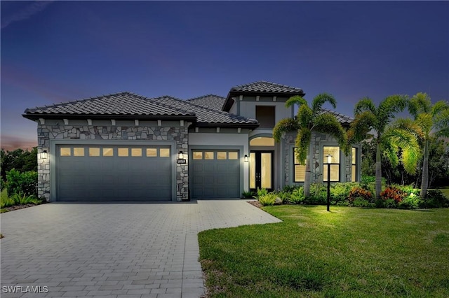 mediterranean / spanish house featuring a yard and a garage