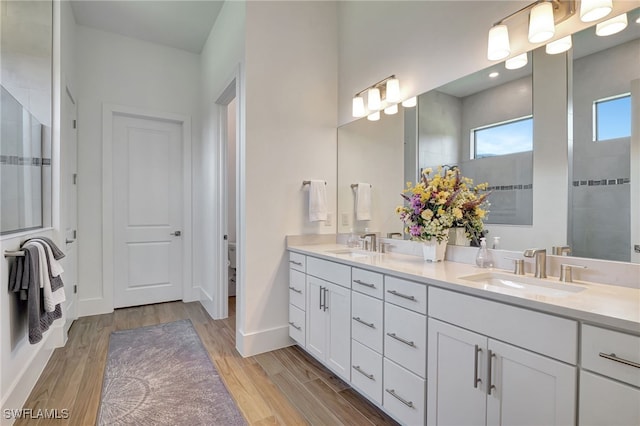 bathroom featuring a shower, toilet, vanity, and hardwood / wood-style flooring