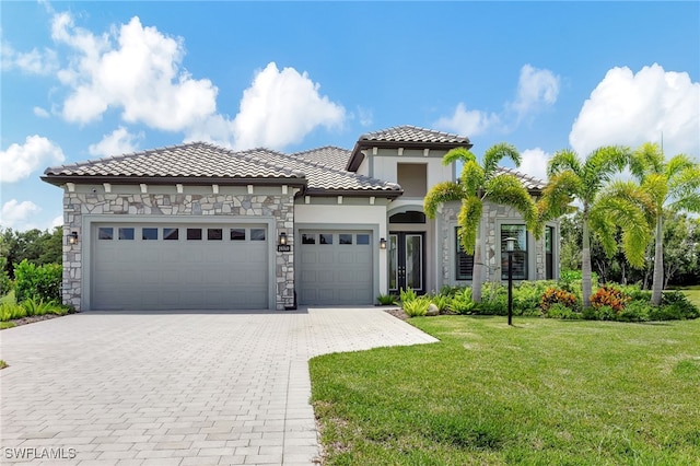 19749 Panther Island Blvd, Estero, FL 33928 - mediterranean / spanish-style home featuring an attached garage, decorative driveway, a front yard, a tiled roof, and stone siding