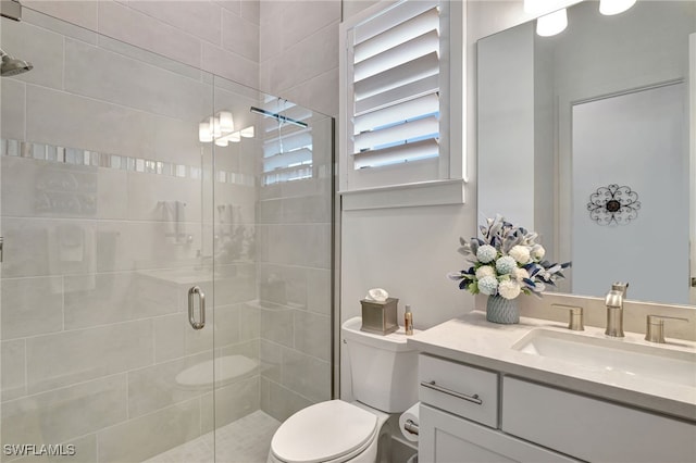 bathroom featuring vanity, toilet, and a shower with shower door