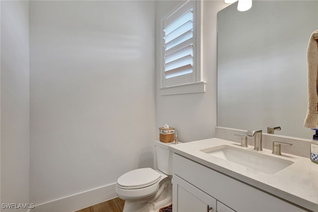 bathroom featuring vanity, hardwood / wood-style flooring, and toilet