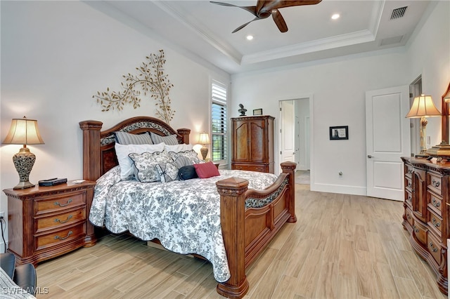 bedroom with light hardwood / wood-style flooring, a raised ceiling, ceiling fan, and crown molding