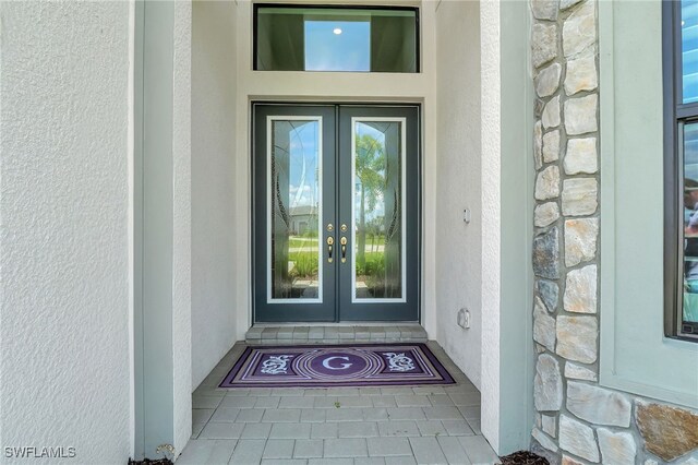 19749 Panther Island Blvd, Estero, FL 33928 - property entrance with french doors, stone siding, and stucco siding