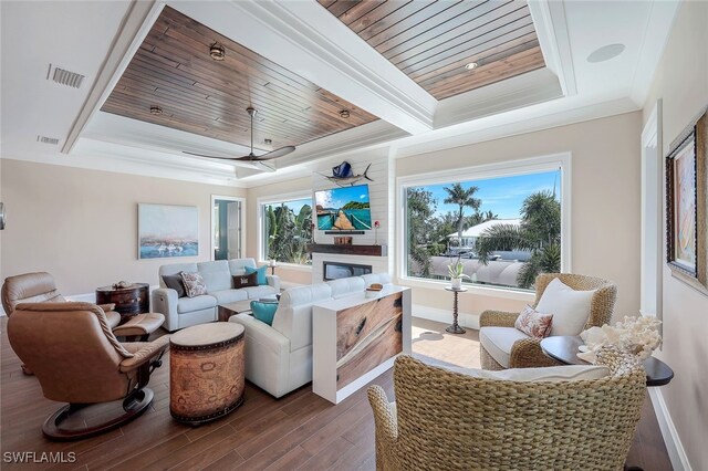 living room with wooden ceiling, ceiling fan, ornamental molding, and a tray ceiling