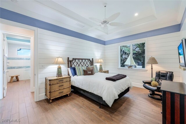 bedroom featuring a tray ceiling, ceiling fan, and hardwood / wood-style flooring