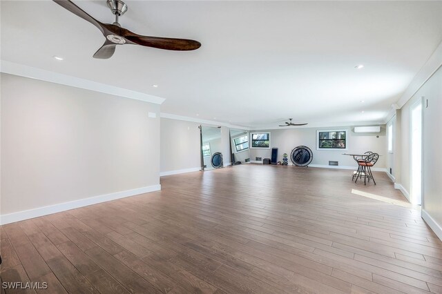 exercise area featuring plenty of natural light, ornamental molding, and light wood-type flooring