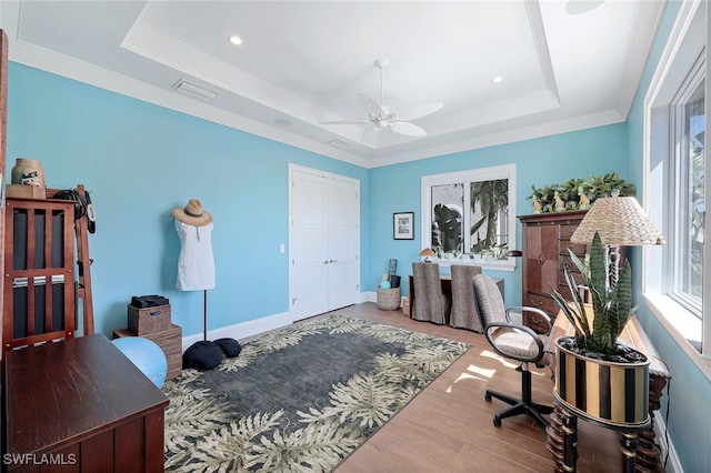 office area featuring hardwood / wood-style flooring, a raised ceiling, ceiling fan, and ornamental molding