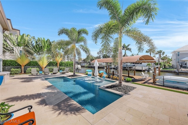 view of swimming pool featuring a water view, a boat dock, and a patio area