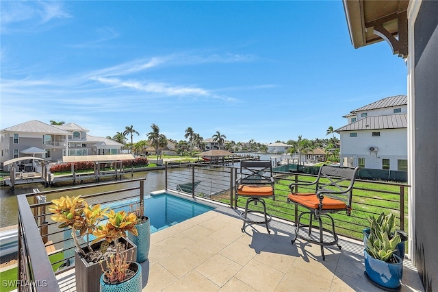 view of patio featuring a balcony and a water view