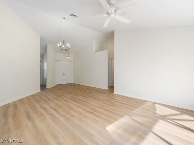 unfurnished living room with ceiling fan with notable chandelier, light hardwood / wood-style floors, and high vaulted ceiling