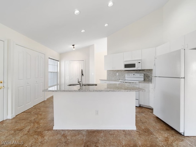 kitchen featuring white cabinets, white appliances, a center island with sink, and vaulted ceiling